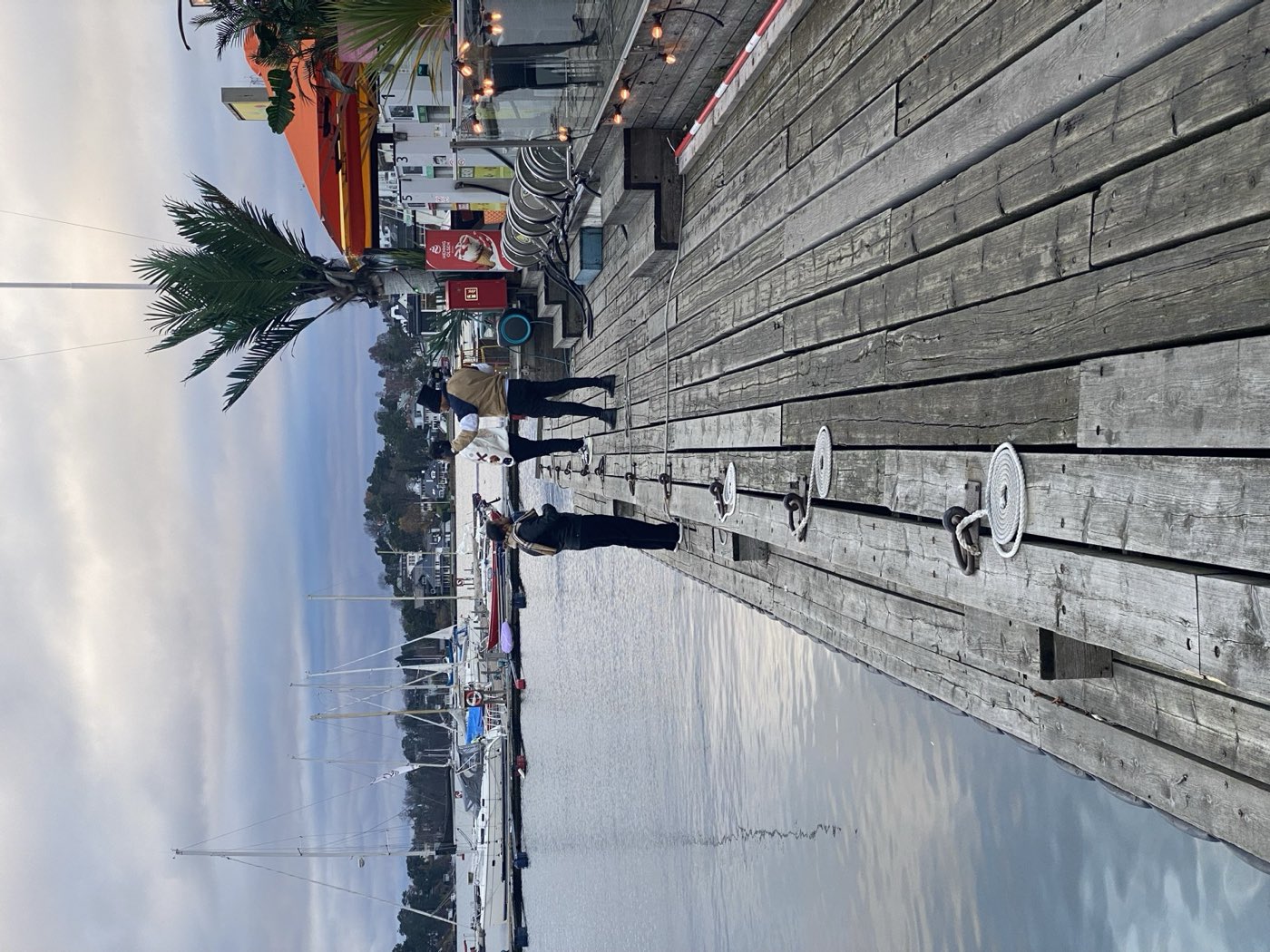 Small crew filming on a wooden jetty beside the water in Norway