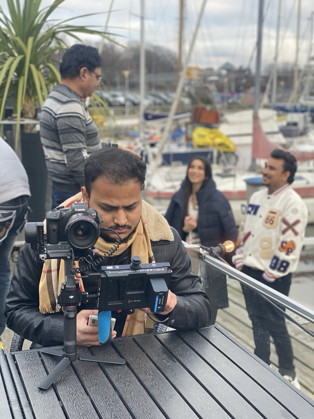 Camera operator with gimbal filming a music video at a marina in Norway for Gringo Entertainments